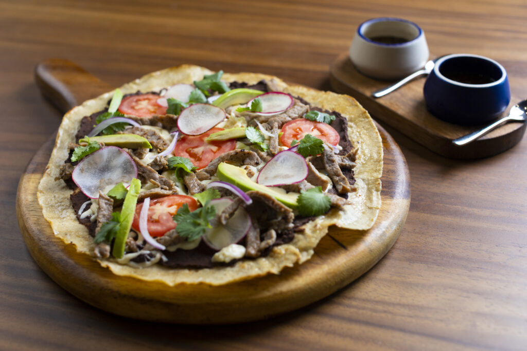 Meat taco with avocado, tomatoes, coriander and radish