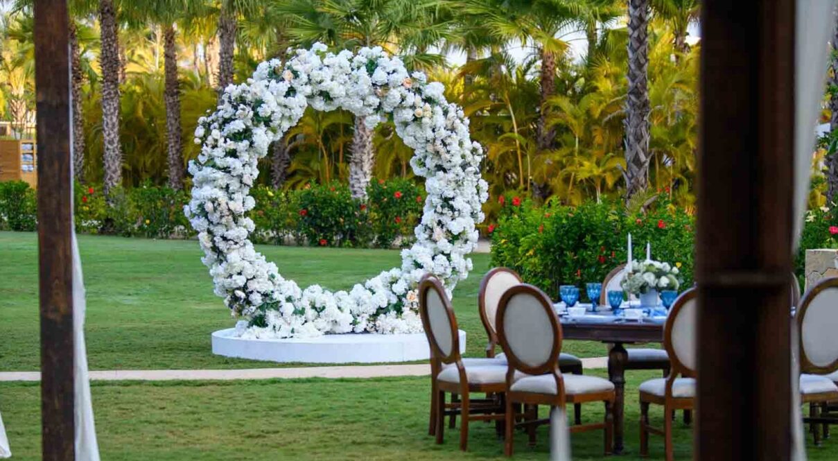Mesa con cubiertos azules y decoración de flores blancas.