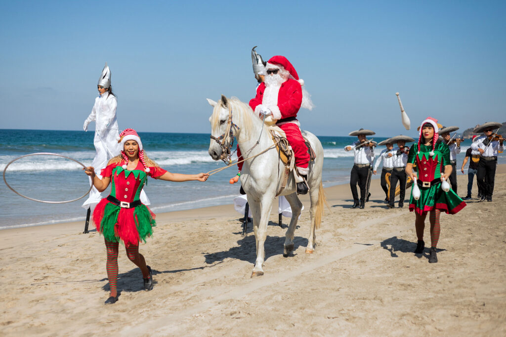 People in Christmas costumes relax on the beach, enjoying an amazing sea view.