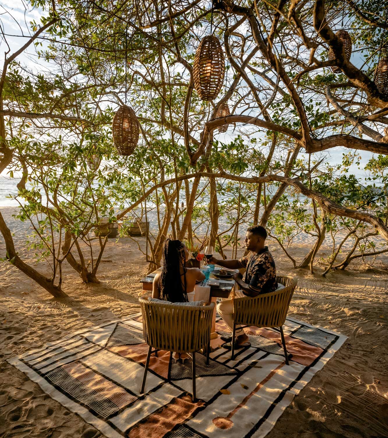 A couple is enjoying a lovely breakfast together on the beach by the shore.