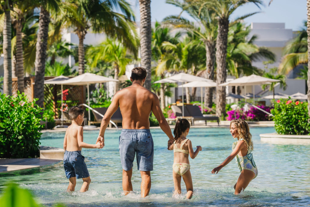 Happy family walking on the swimming pool