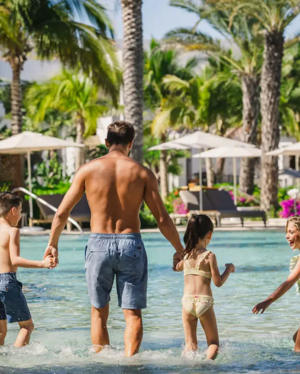 Happy family walking on the swimming pool
