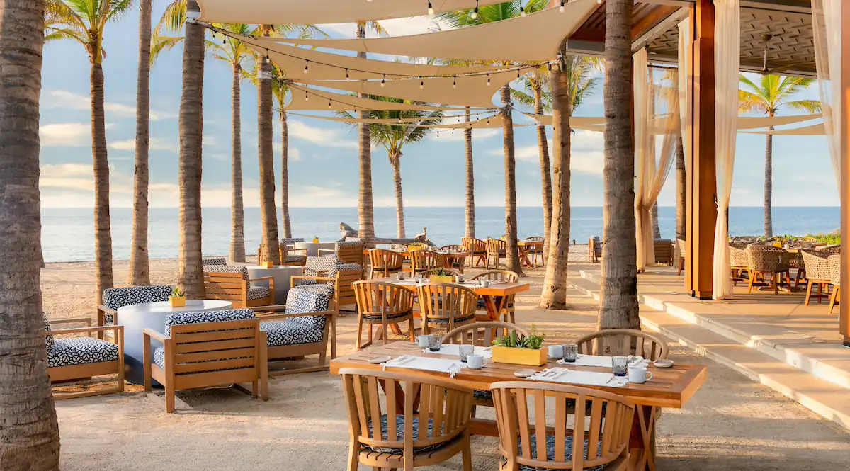 Sitting area with bunch of chair and tables on the beach
