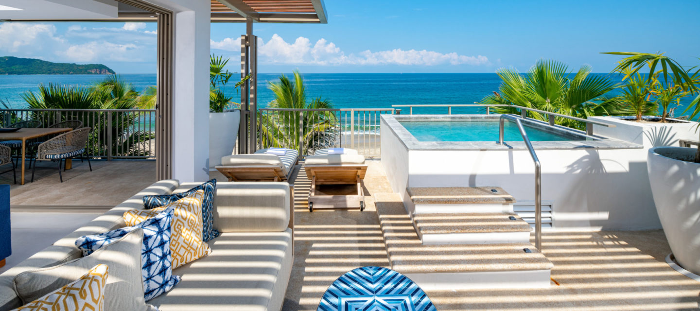 Balcón de la habitación del hotel con dos camas de piscina con vista al mar