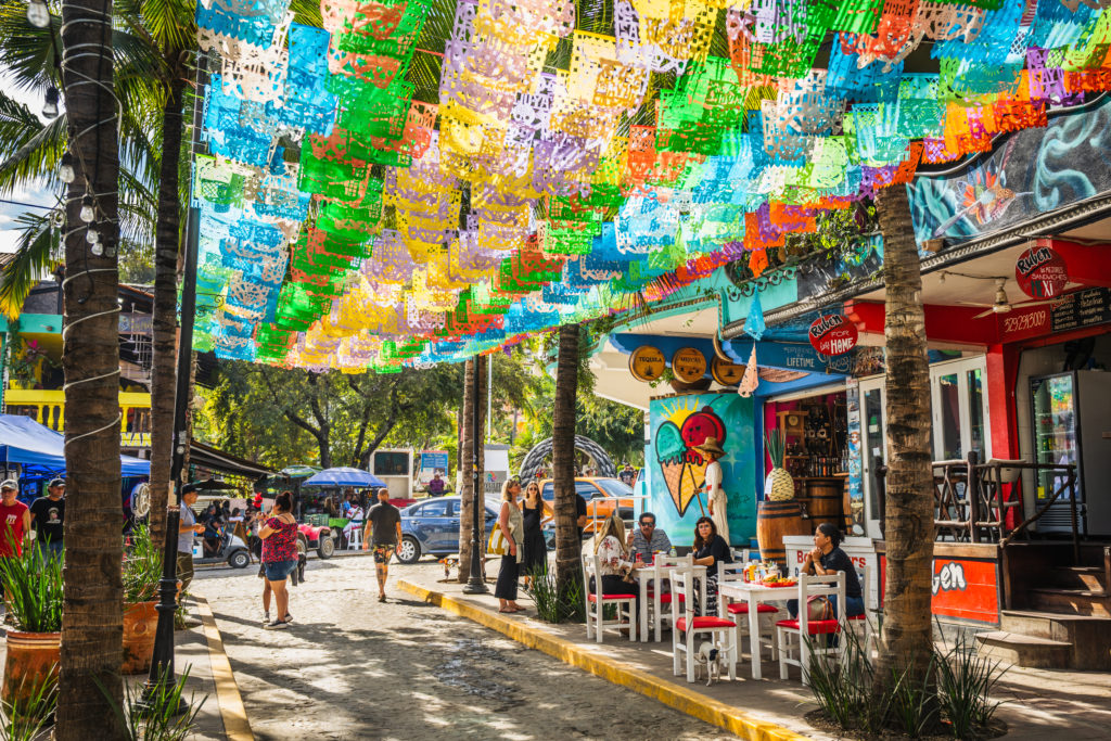 Camino decorado con artículos de colores con tiendas en los alrededores.