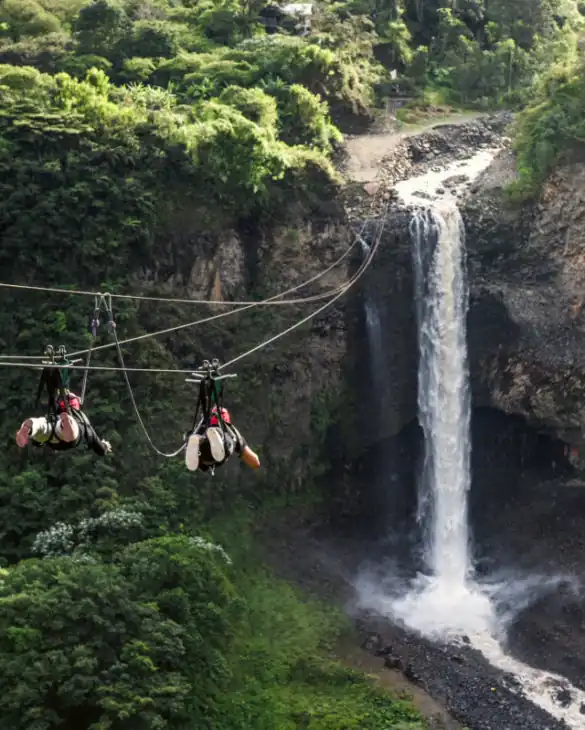 Waterfall falling from the mountain and people using the rope