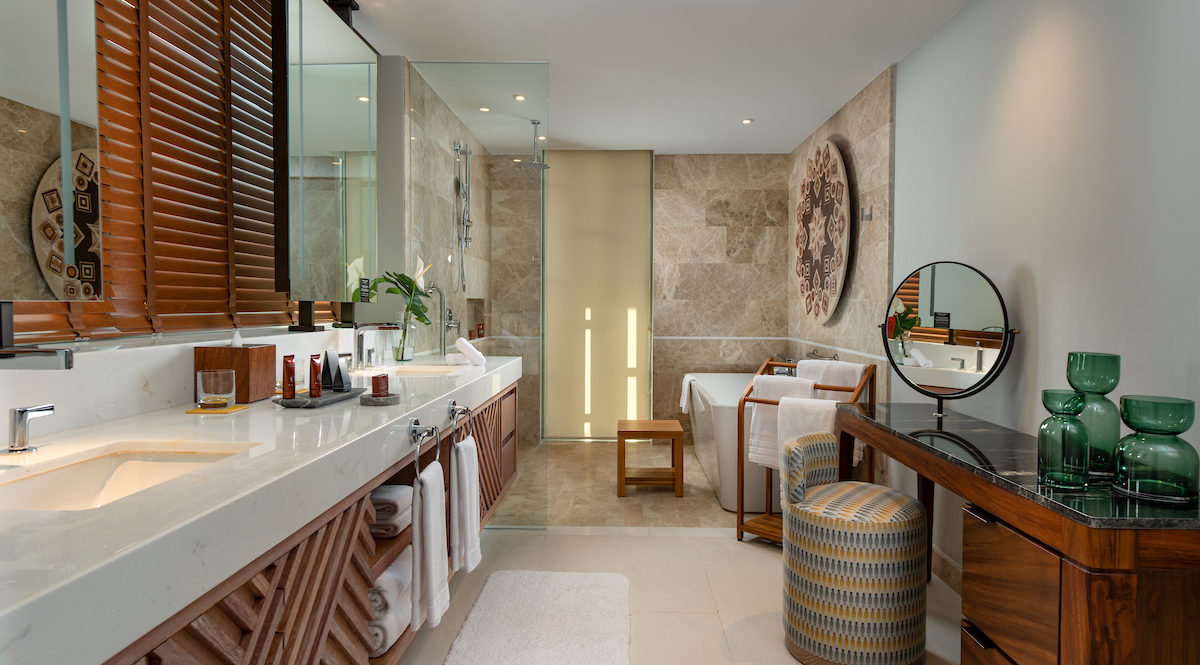 Un baño de habitación de hotel con espejo y elementos esenciales.