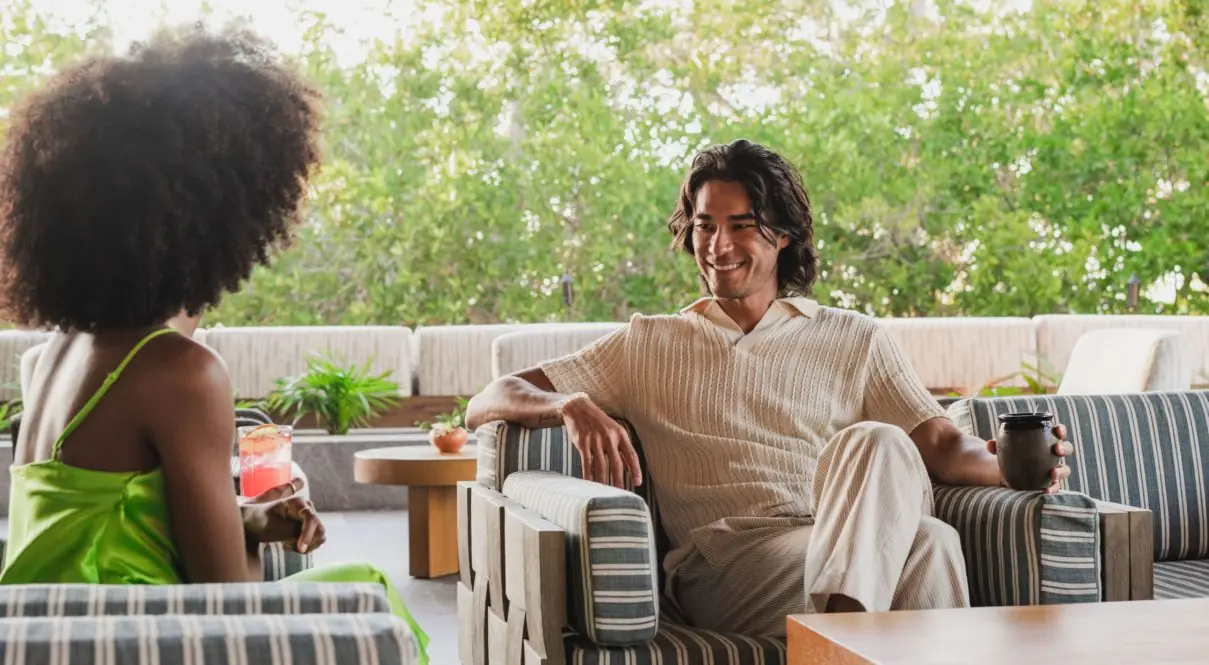 Hombre y mujer sentados mirándose y sonriendo