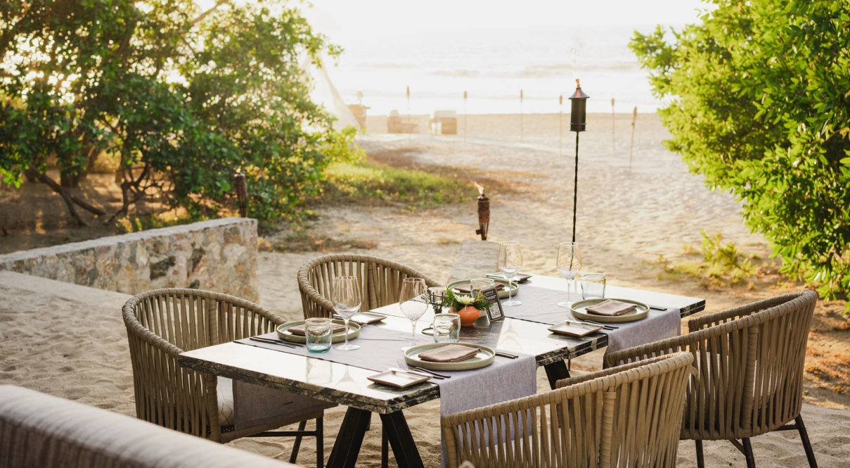 Imagen de la mesa de comedor en la playa con vista al mar