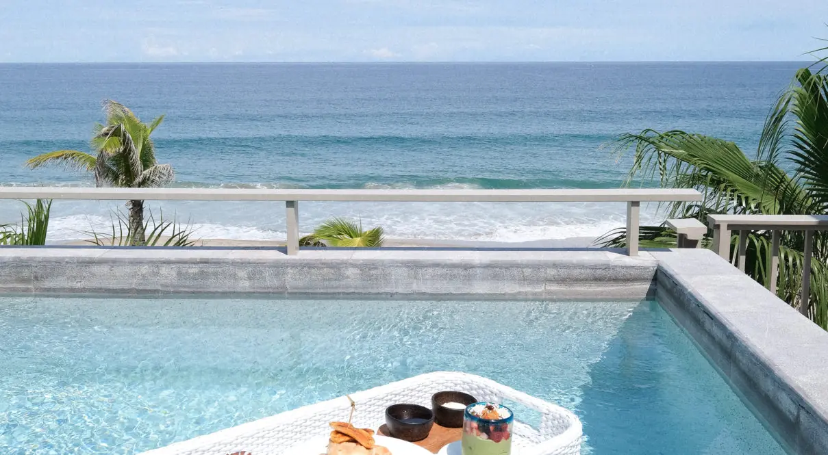 Imagen de mesa con comida en la piscina.