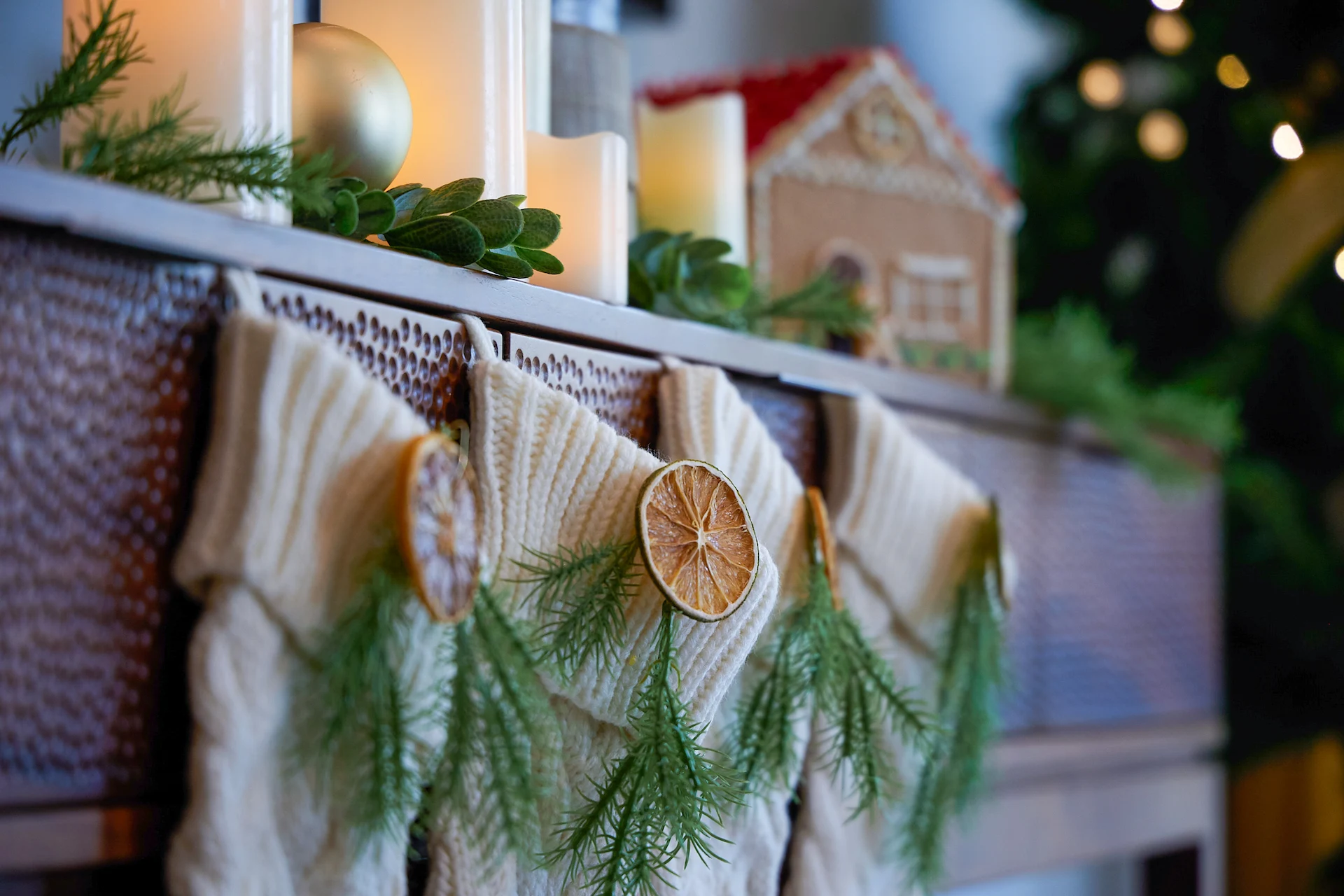 A table is beautifully decorated with small woolen cloths, green leaves, and candles.
