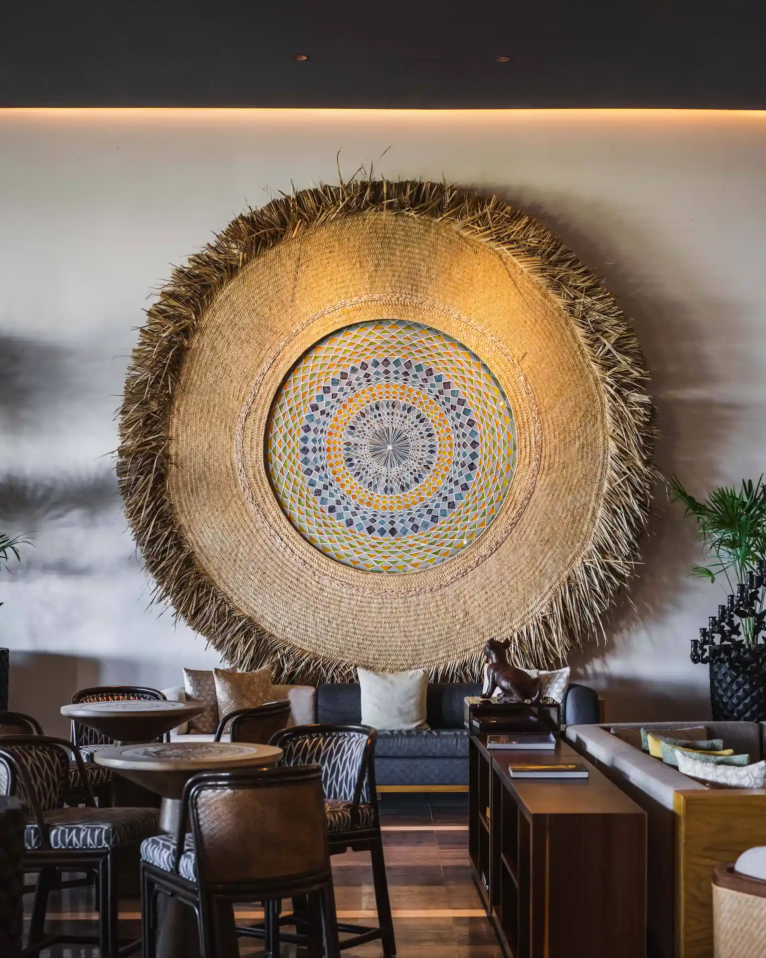 A meticulously arranged lounge space featuring Pottery Barn Sunny Handwoven Basket Wall Art.