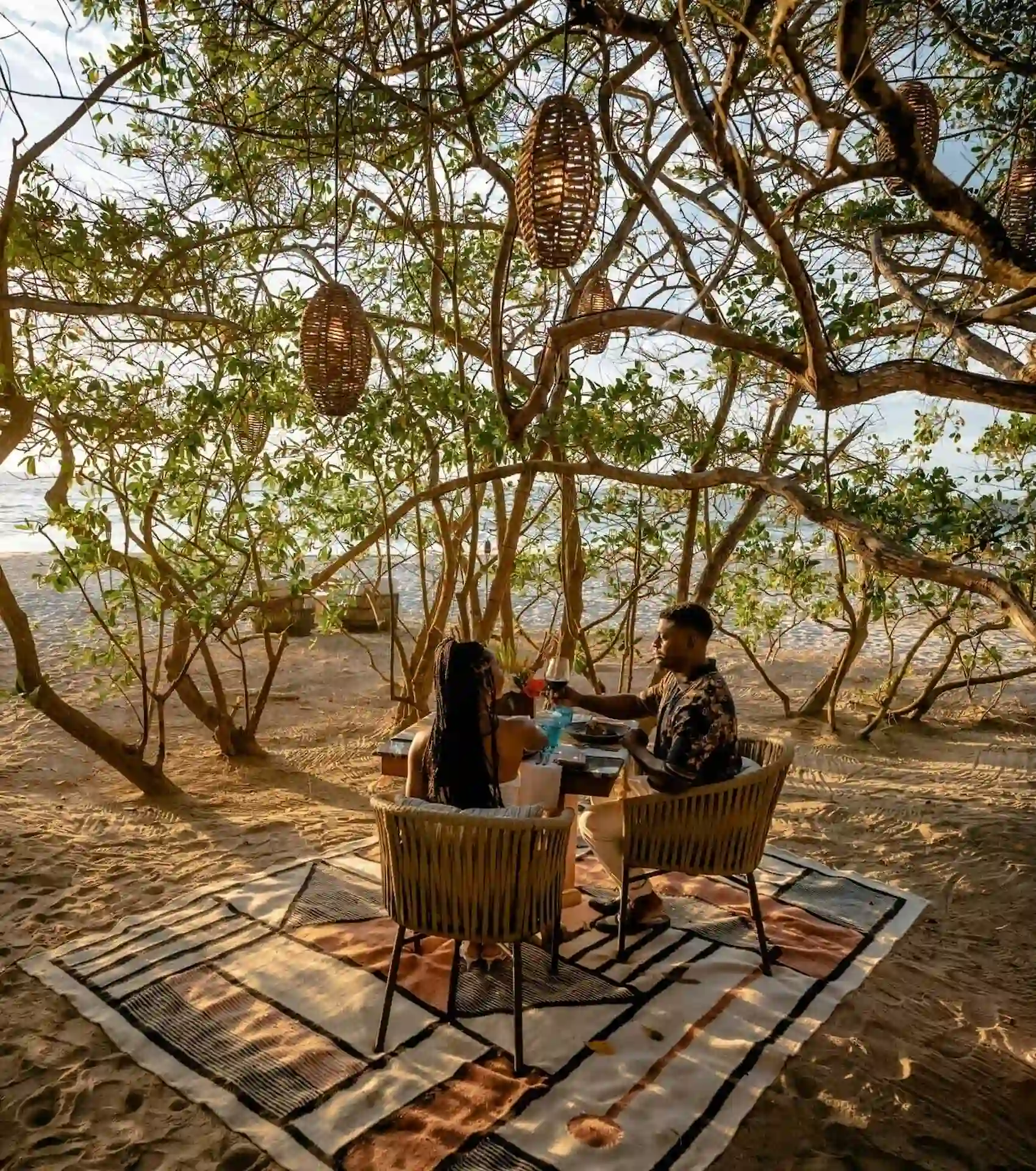 A couple is enjoying a lovely breakfast together on the beach by the shore.