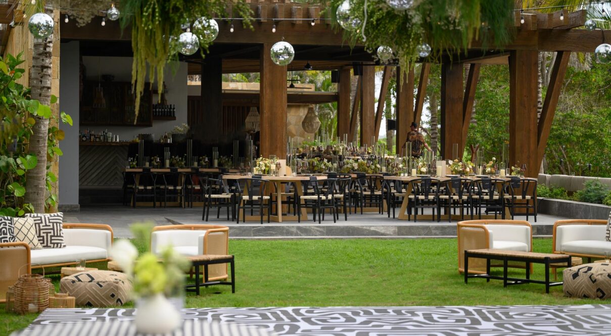 Numerous tables with chairs are properly arranged and ready for the celebration.