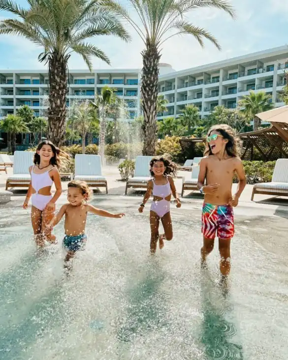 Children frolic by the pool's edge, enjoying playful moments in the sunshine.