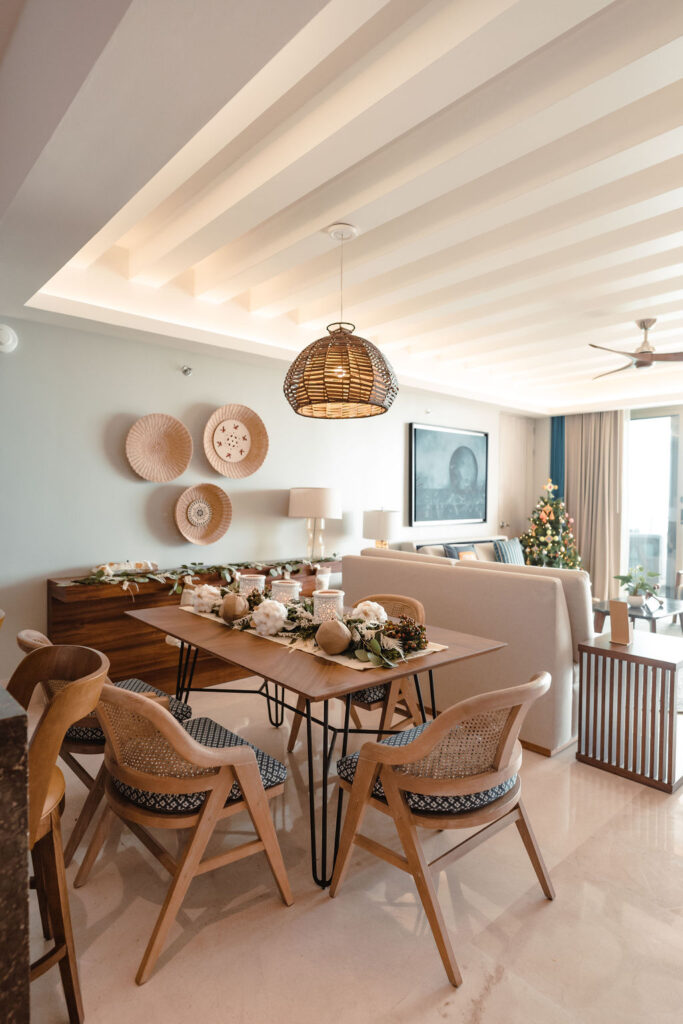A well-set dining table adjacent to the living area with a pendant lamp above it.