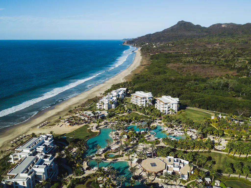 A stunning aerial vista of a seaside resort, framed by a distant mountain.