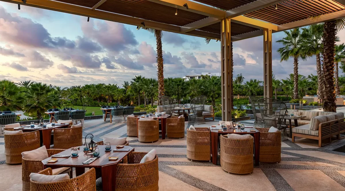 Thoughtfully set outdoor dining, surrounded by lush greenery and an enchanting evening vista.