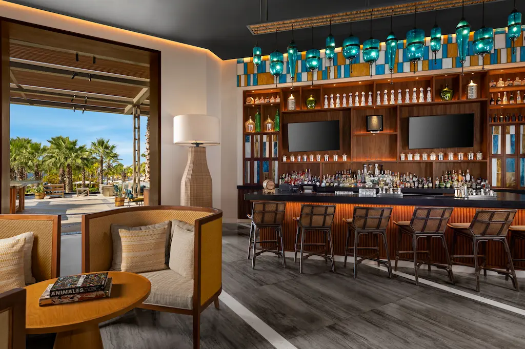 Well-arranged bar seating with an elegant chandelier suspended from the ceiling above.