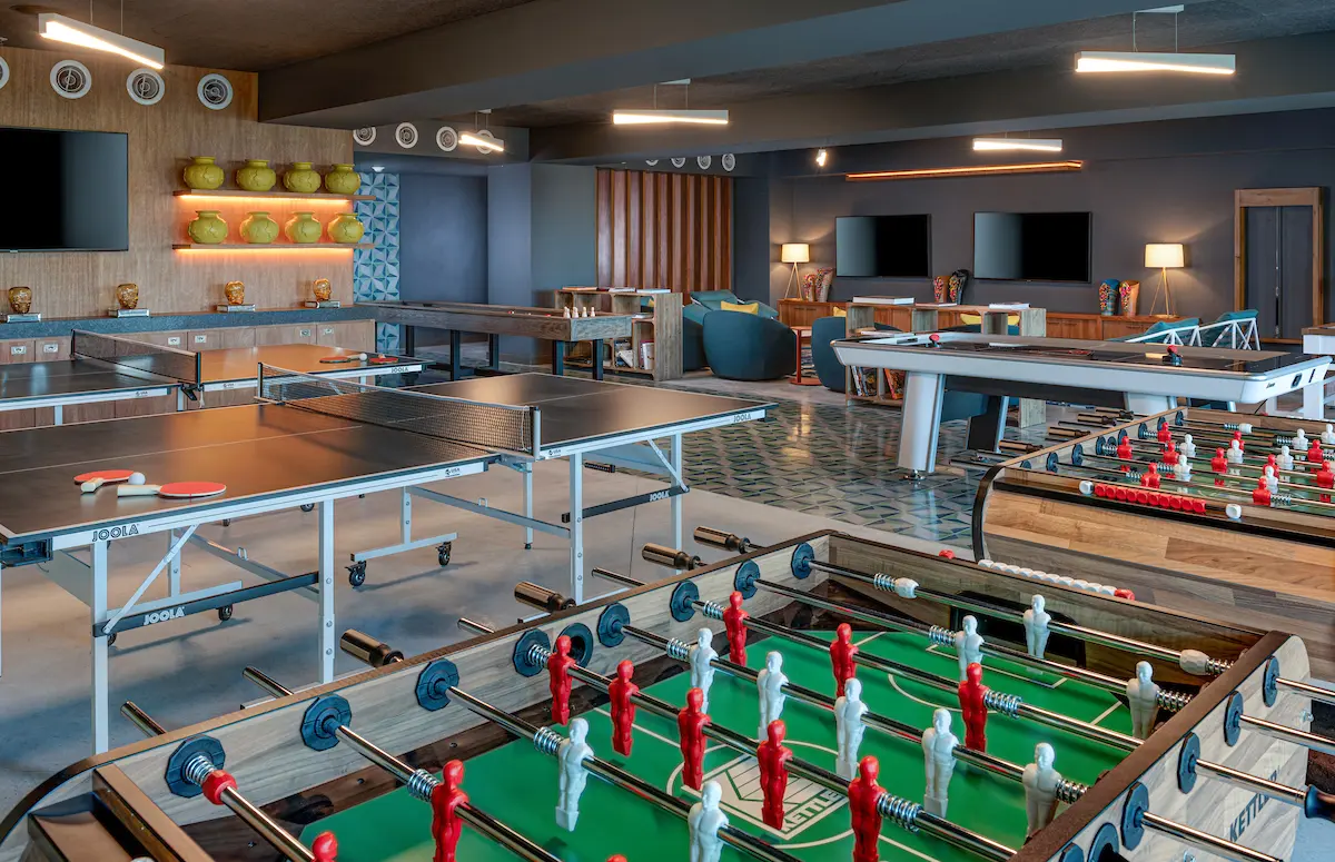 An indoor playroom featuring various gaming tables for diverse entertainment options.