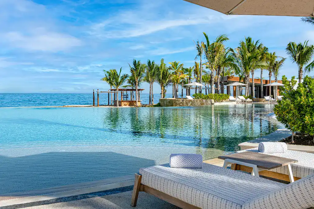 The poolside seating area offers a splendid view of the breathtaking sea.