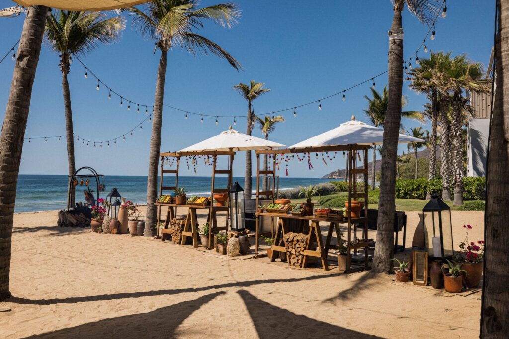 Fruits are beautifully arranged on the beach, ready for customers to enjoy.